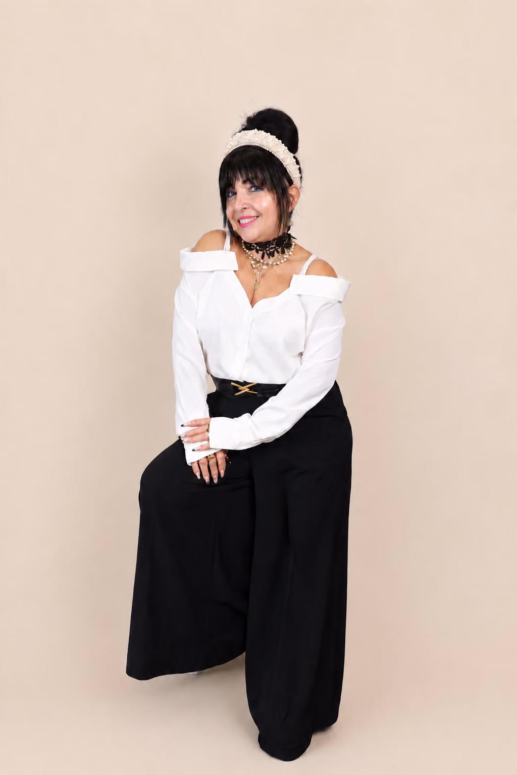 Mimi, founder and head stylist of Mimi's Touch Salon, seated in the salon.