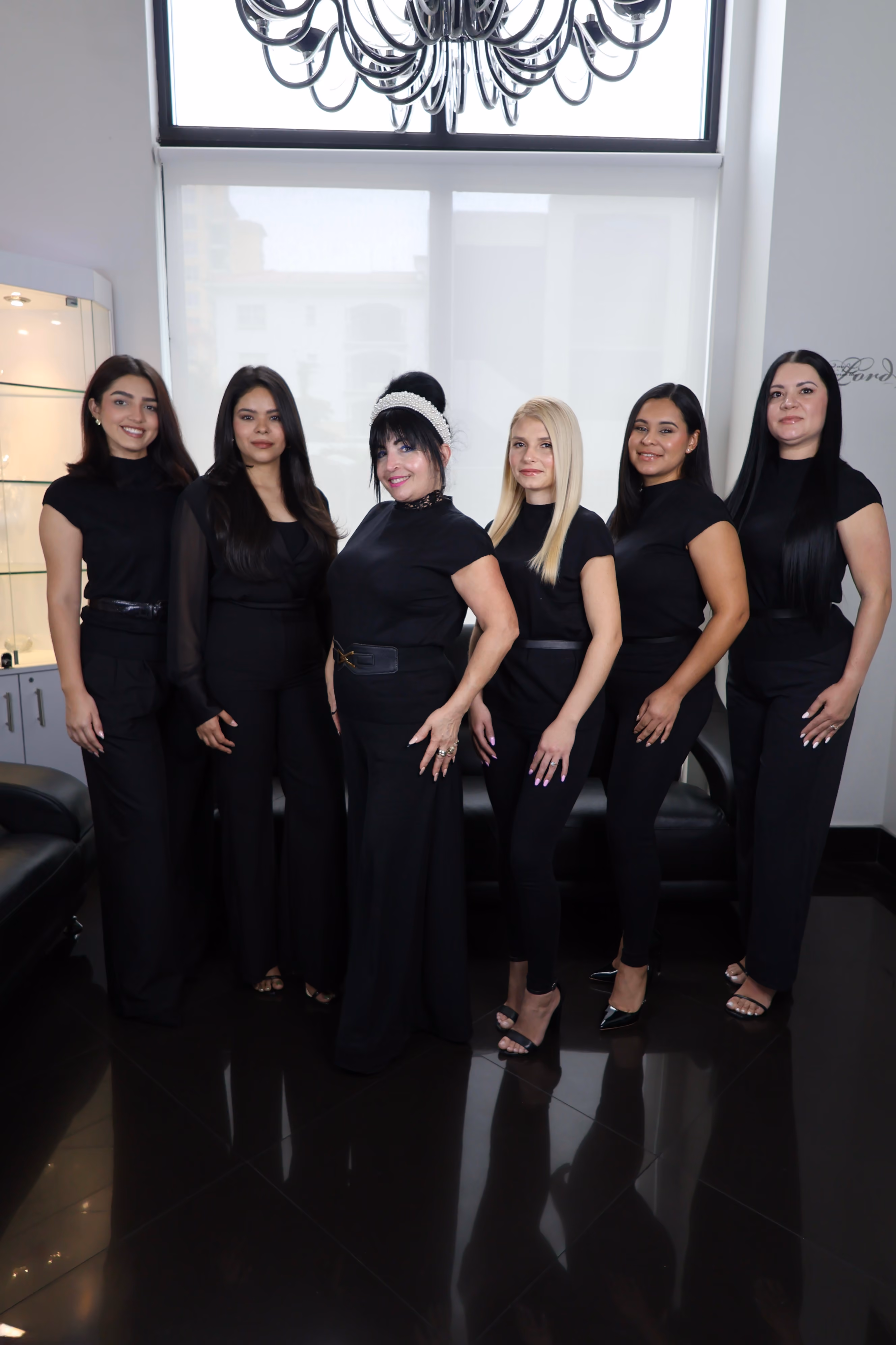 Mimi with the stylists of Mimi's Touch Salon, all in black, in the salon on Ponce de Leon Boulevard.